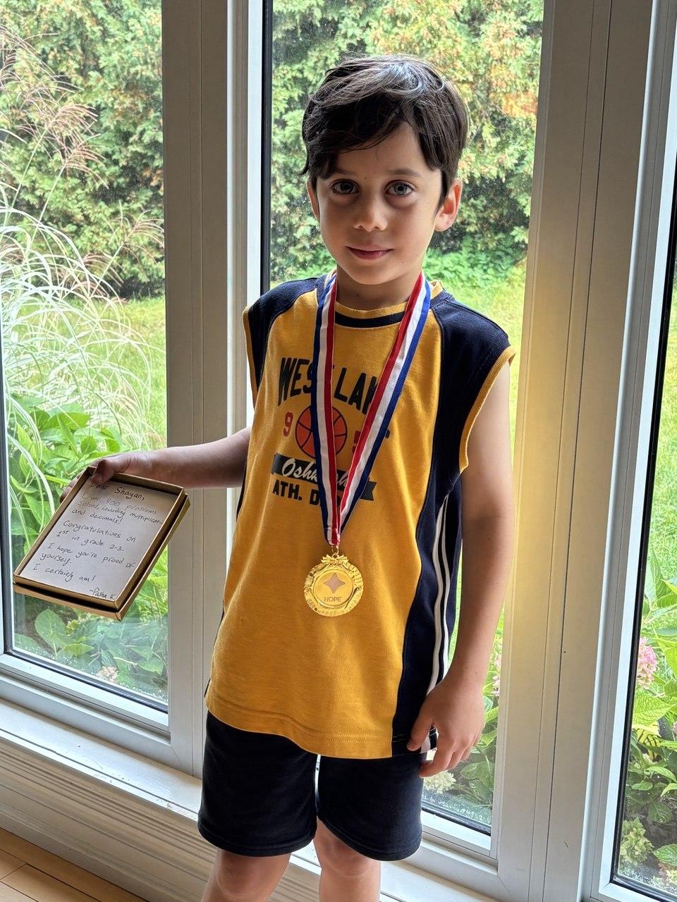 September HOPE Contest winner in a yellow jersey, wearing a gold medal and holding a handwritten note